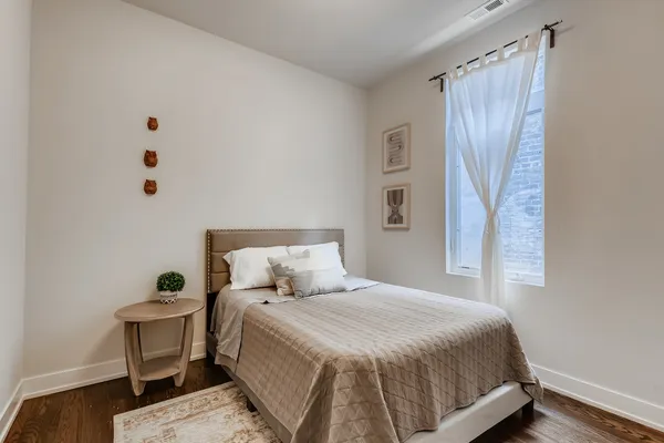 a bedroom with a bed and wooden floor