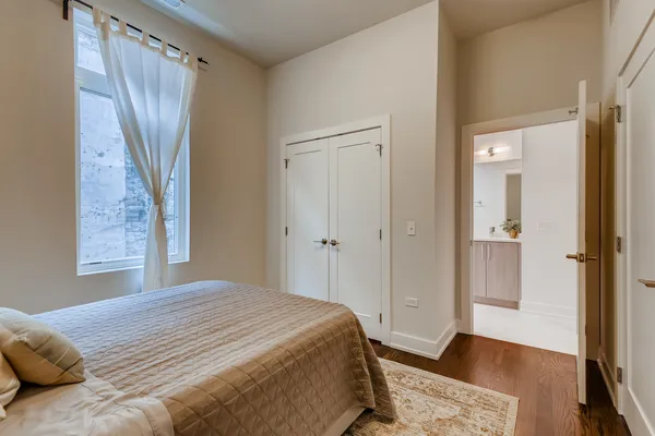 a bedroom with a bed and a wooden floor