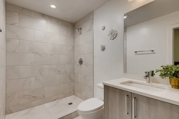 a bathroom with a sink a toilet and shower