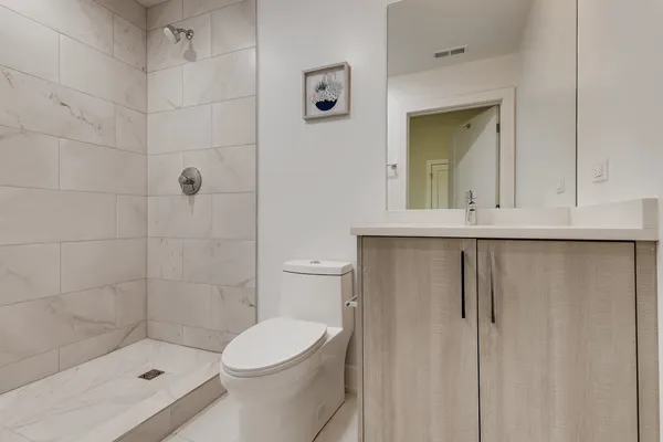 a bathroom with a sink a toilet and shower