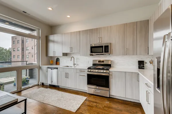 a kitchen with stainless steel appliances a stove sink microwave and cabinets