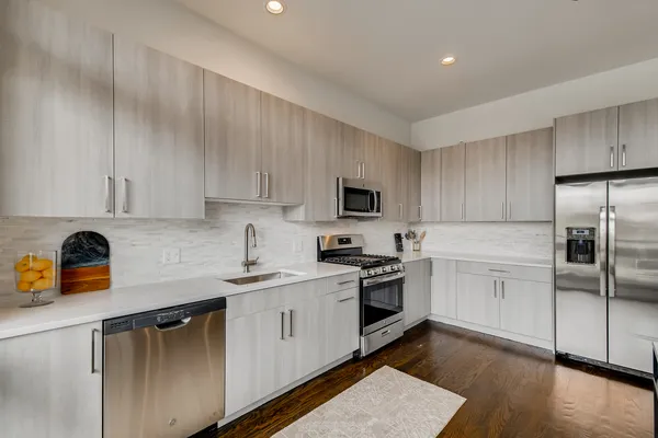 a kitchen with a sink white cabinets and stainless steel appliances