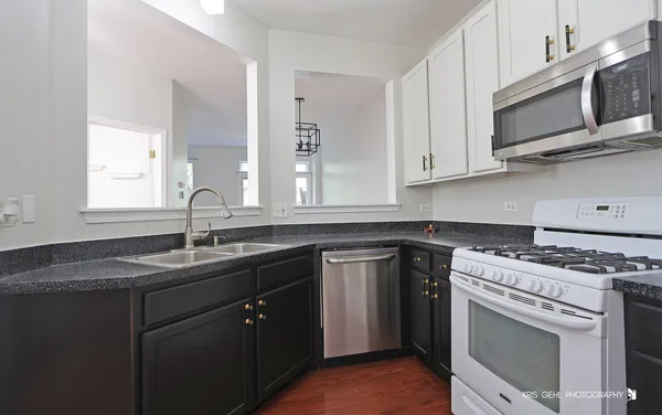 a kitchen with stainless steel appliances granite countertop a sink stove top oven and microwave