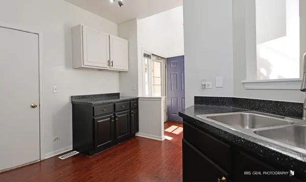 a kitchen with granite countertop a refrigerator sink and cabinets