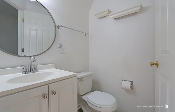 a bathroom with a sink vanity mirror and toilet