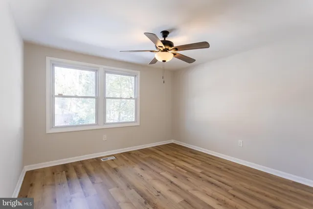 a bathroom with a toilet a sink a mirror a vanity and window