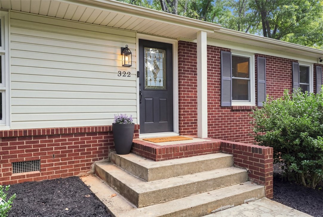 Concrete steps lead to an inviting entry accented by classic brick and siding details.