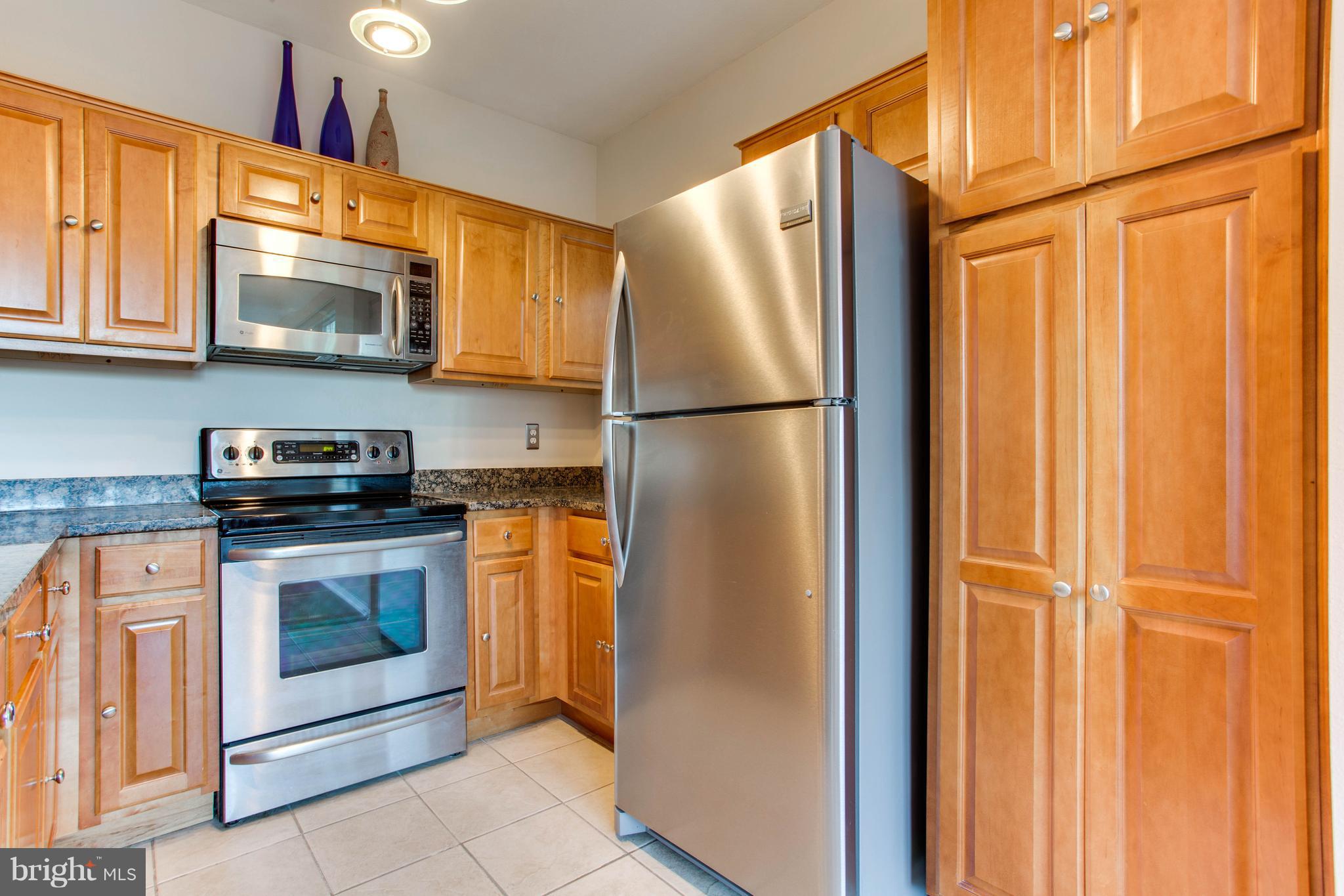 1600 Spring Gate Dr., Unit 2207 McLean, VA 22102 - Photo 13 of 29 a kitchen with stainless steel appliances granite countertop a refrigerator and a stove top oven