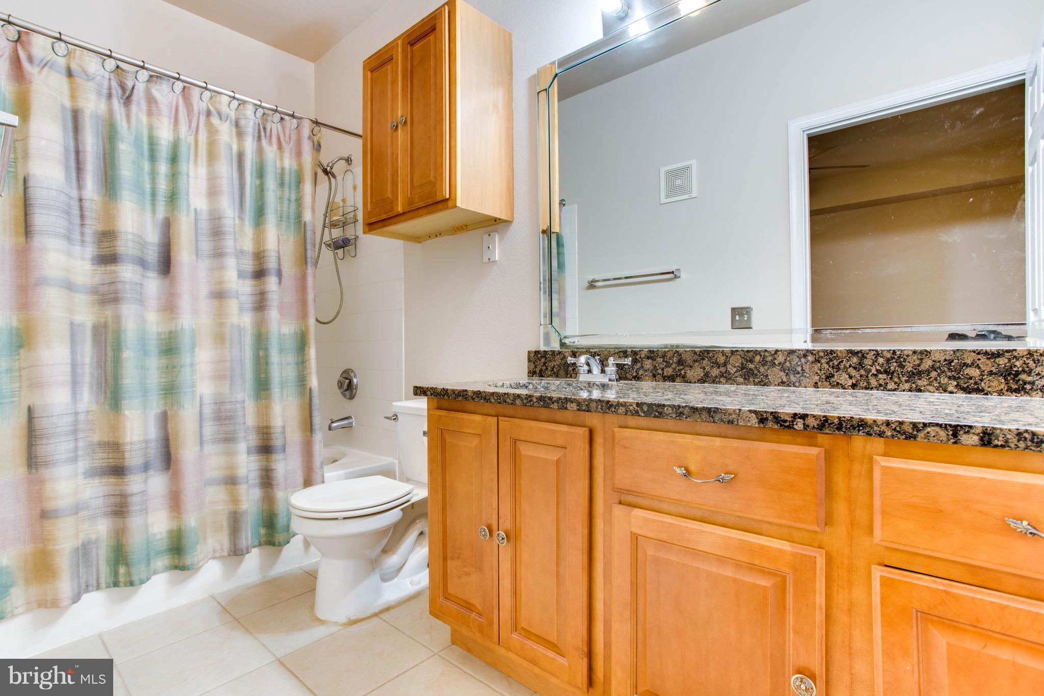 1600 Spring Gate Dr., Unit 2207 McLean, VA 22102 - Photo 18 of 29 a bathroom with a granite countertop sink and a mirror