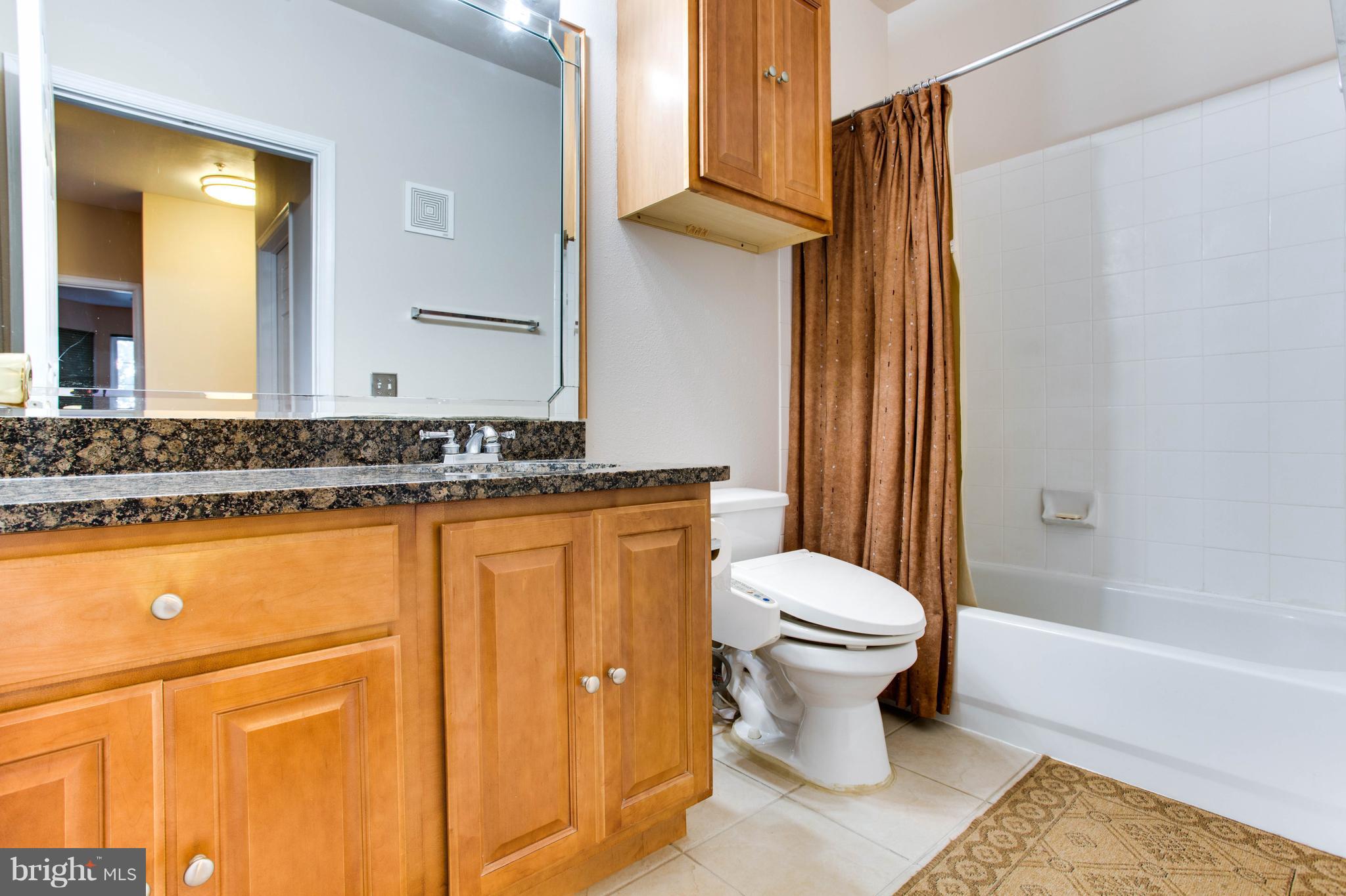 1600 Spring Gate Dr., Unit 2207 McLean, VA 22102 - Photo 22 of 29 a bathroom with a granite countertop toilet sink and mirror