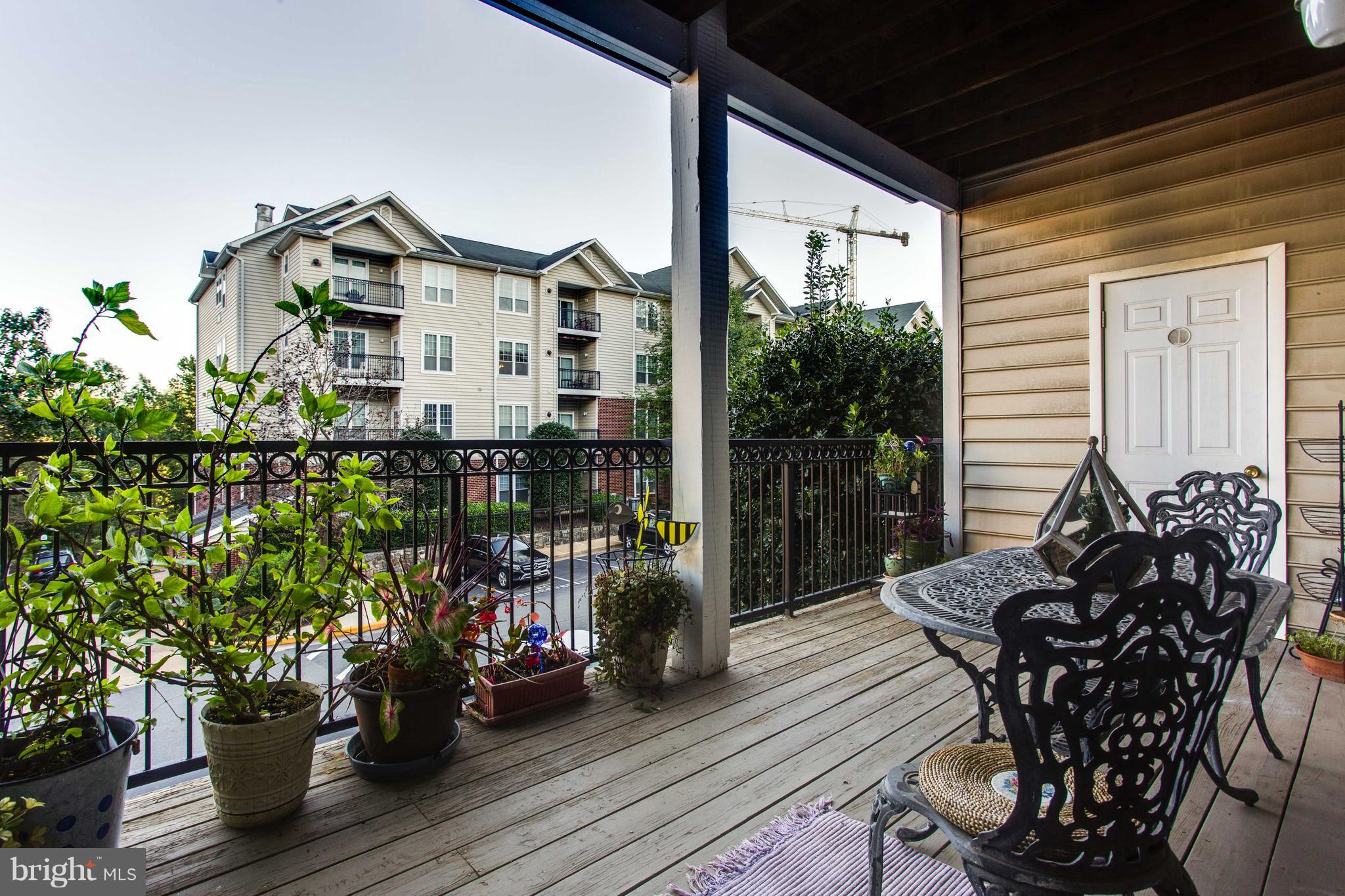 1600 Spring Gate Dr., Unit 2207 McLean, VA 22102 - Photo 24 of 29 a view of a deck with table and chairs and potted plants