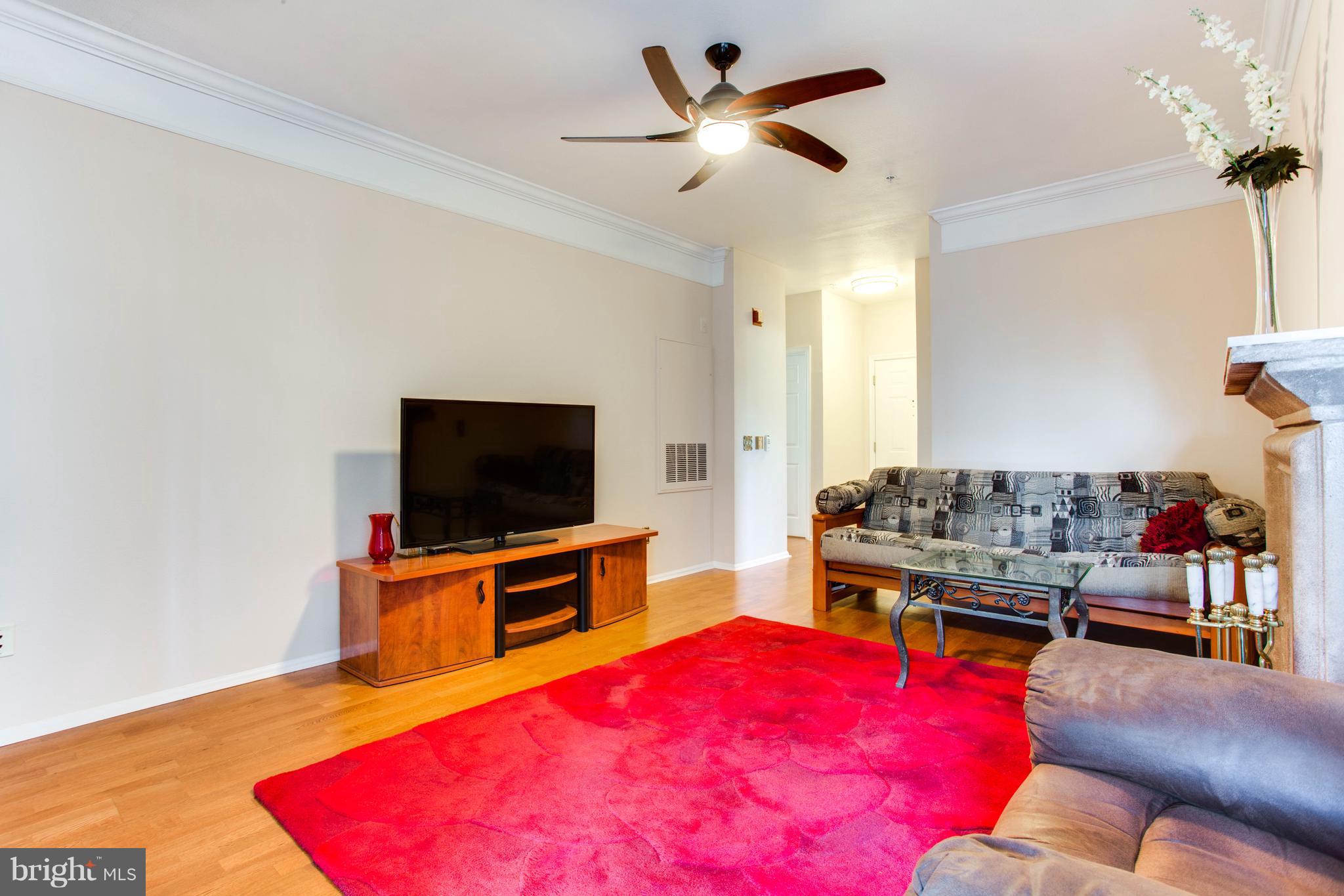 1600 Spring Gate Dr., Unit 2207 McLean, VA 22102 - Photo 8 of 29 a living room with a flat screen tv and a couch