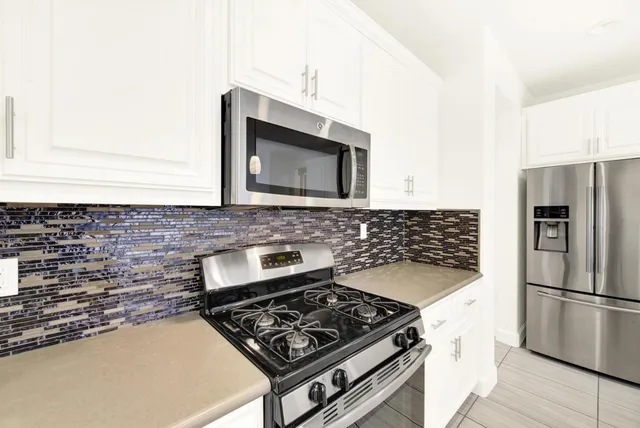 an empty room with windows and ceiling fan