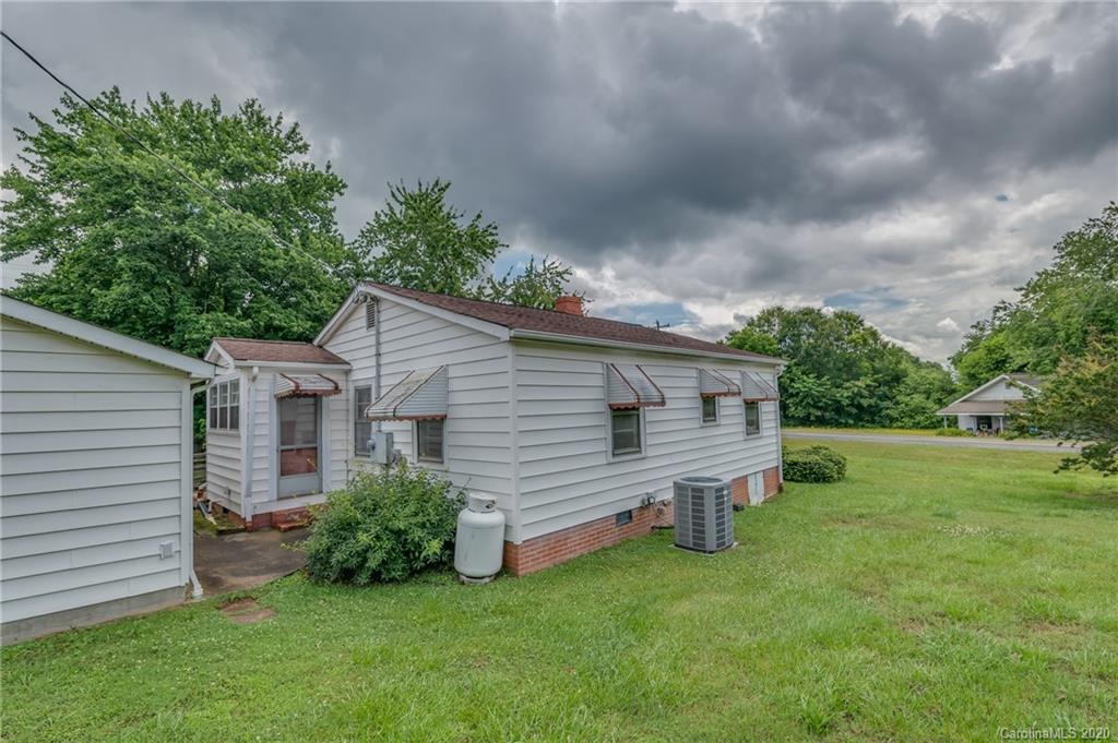 428 Kelly Road Forest City, NC 28043 - Photo 4 of 24 a view of a house with a yard plants and large tree