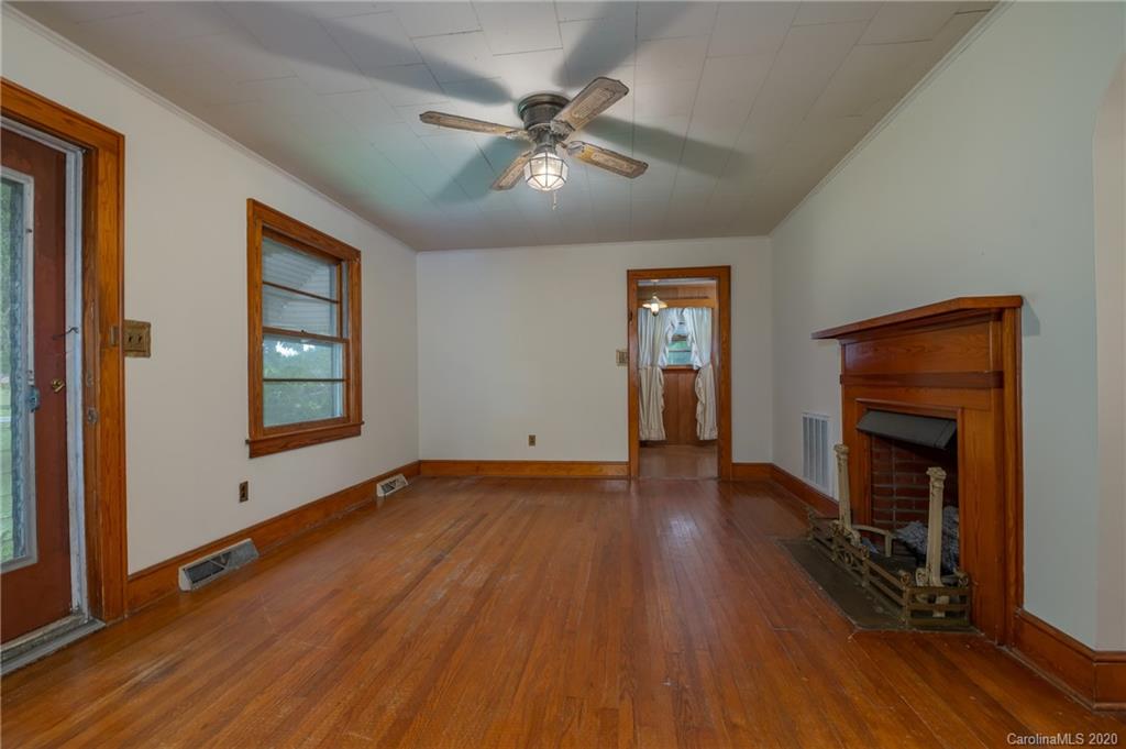 428 Kelly Road Forest City, NC 28043 - Photo 10 of 24 an empty room with wooden floor a ceiling fan and windows