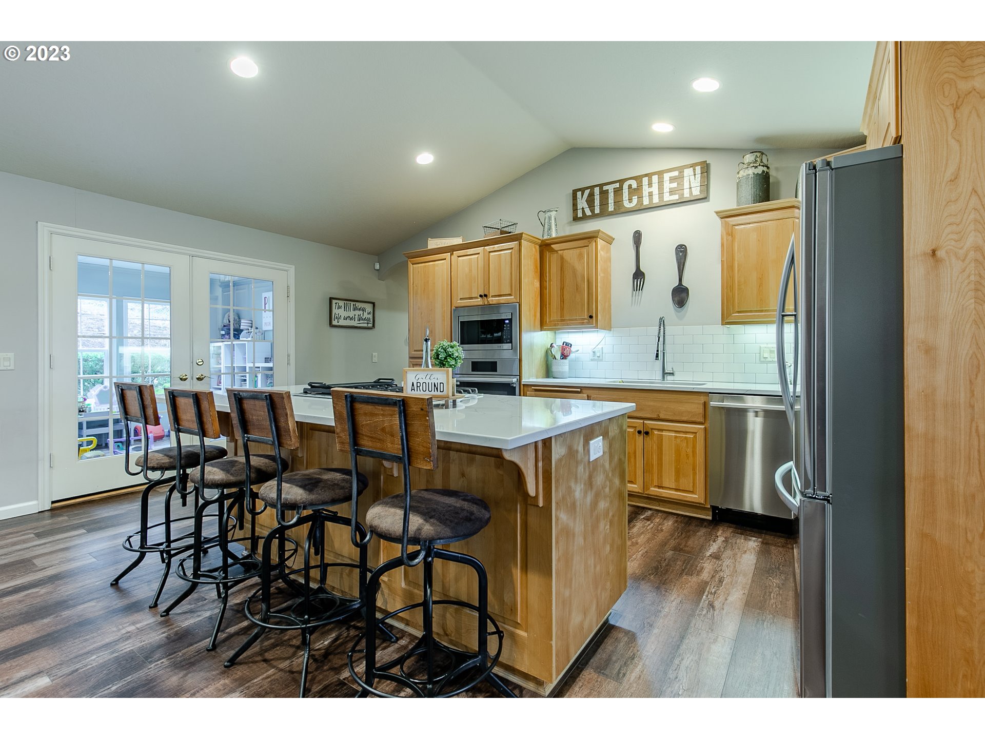 2353 35th Street Springfield, OR 97477 - Photo 9 of 32 a open kitchen with stainless steel appliances kitchen island granite countertop a refrigerator a stove a sink dishwasher with a dining table and chairs