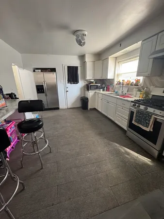 a kitchen with stainless steel appliances granite countertop a sink and white cabinets