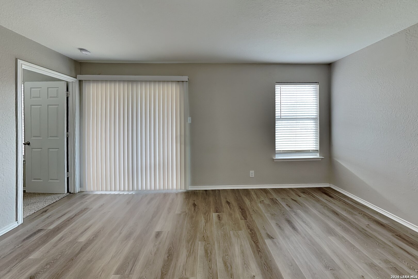 6510 Poseidon Way Converse, TX 78109 - Photo 2 of 16 an empty room with wooden floor and windows