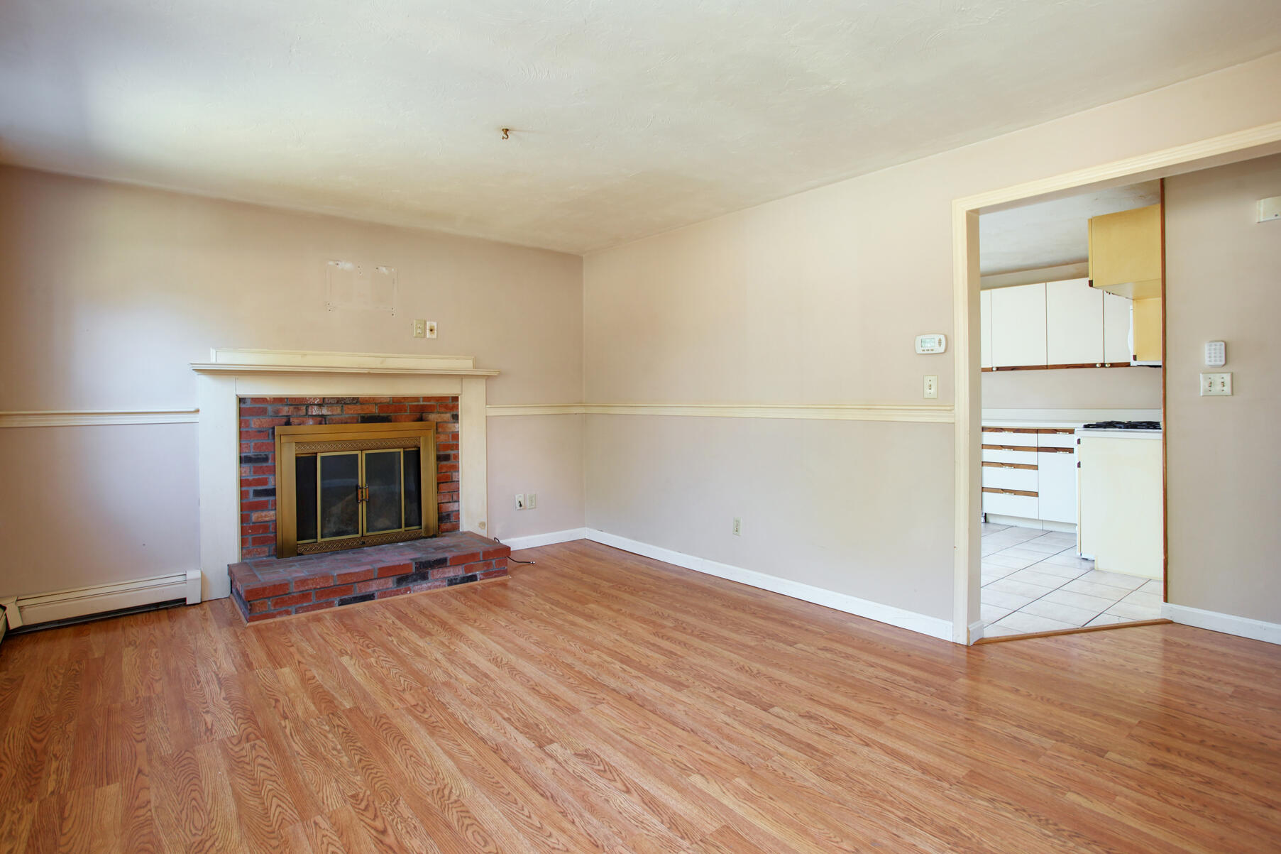 319 Cotuit Road Mashpee, MA 02649 - Photo 7 of 28 an empty room with wooden floor fireplace and windows