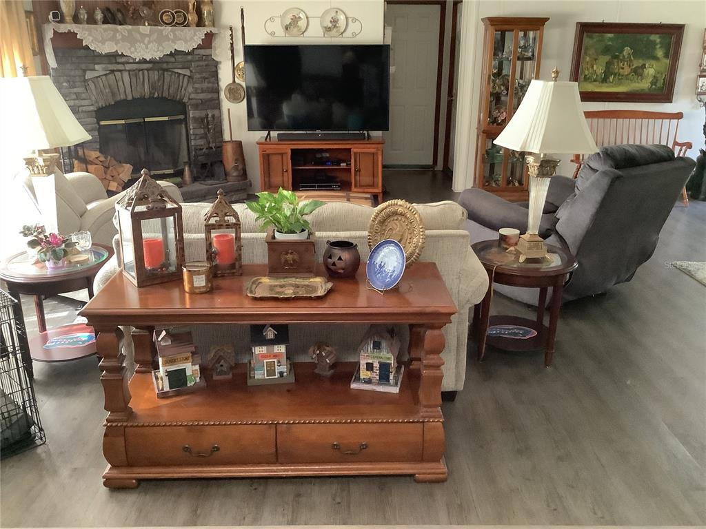 34926 Punch Road Dade City, FL 33523 - Photo 52 of 75 a living room with furniture a flat screen tv and a fireplace