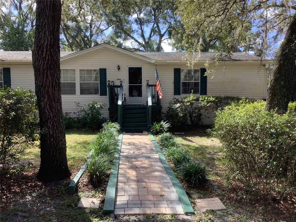 34926 Punch Road Dade City, FL 33523 - Photo 6 of 75 a front view of a house with a garden