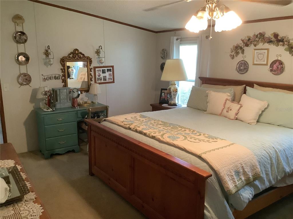 34926 Punch Road Dade City, FL 33523 - Photo 65 of 75 a bedroom with a bed and a chandelier