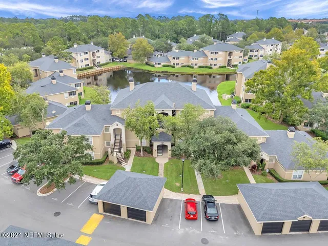 an aerial view of residential houses with outdoor space and swimming pool