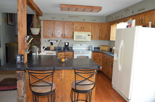 458 East Briarcliff Road Bolingbrook, IL 60440 - Photo 6 of 18 a kitchen with stainless steel appliances granite countertop a stove a refrigerator a sink a dining table and chairs with wooden floor
