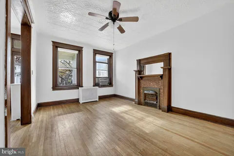 a view of an empty room with a fireplace and a window