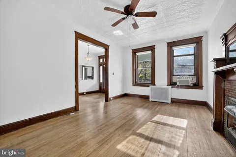 a view of a livingroom with furniture a ceiling fan and wooden floor