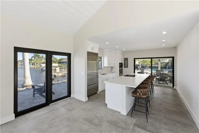 a living room with furniture a floor to ceiling window and an outdoor view