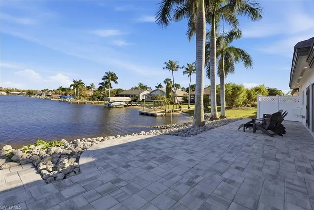 a view of a lake with a lawn chairs and a fire pit