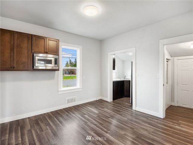 a view of a kitchen with wooden floor and a window