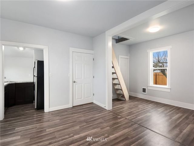 a view of empty room with wooden floor and stairs