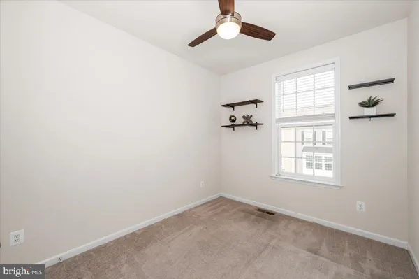 an empty room with a ceiling fan and a window
