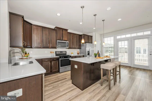 a kitchen with a sink a counter top space a large window and stainless steel appliances