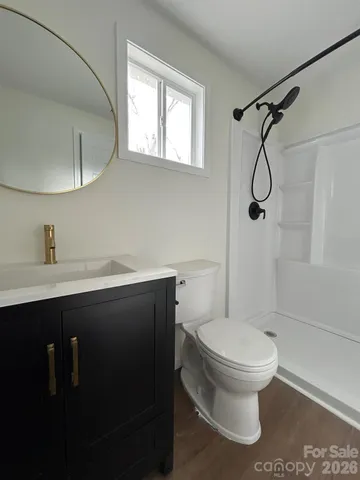 an empty room with wooden floor ceiling fan and windows