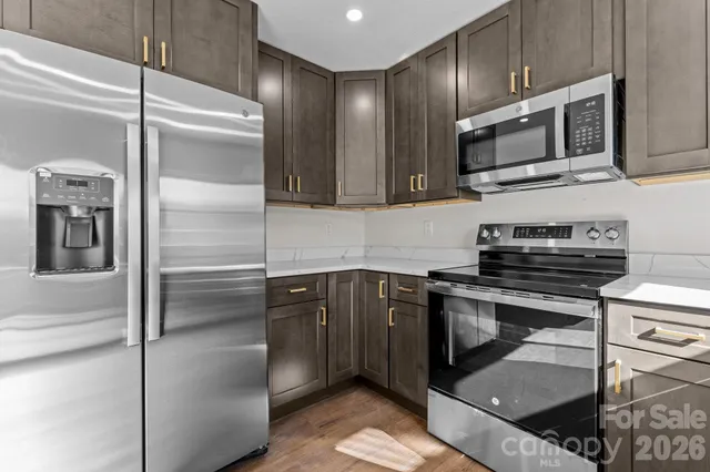 a kitchen with stainless steel appliances granite countertop a refrigerator and a stove top oven