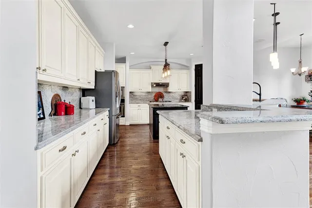 a kitchen with granite countertop a sink cabinets and stainless steel appliances