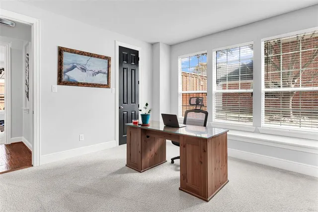 a view of a workspace with furniture and a window