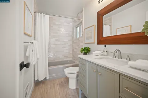 a bathroom with a granite countertop sink a toilet and shower
