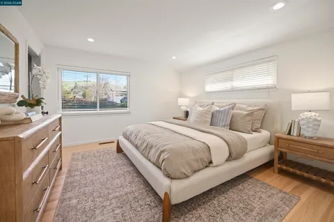 a spacious bedroom with a bed and wooden floor