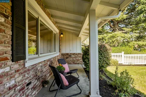 a balcony with table and chairs and wooden fence