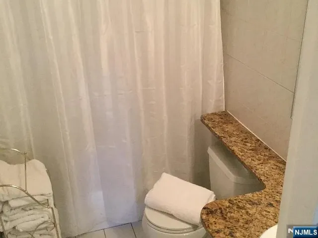a bathroom with a granite countertop and toilet