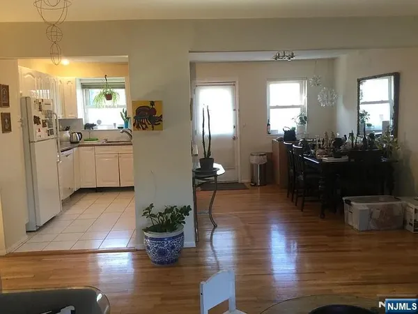 a kitchen with a refrigerator and wooden floor
