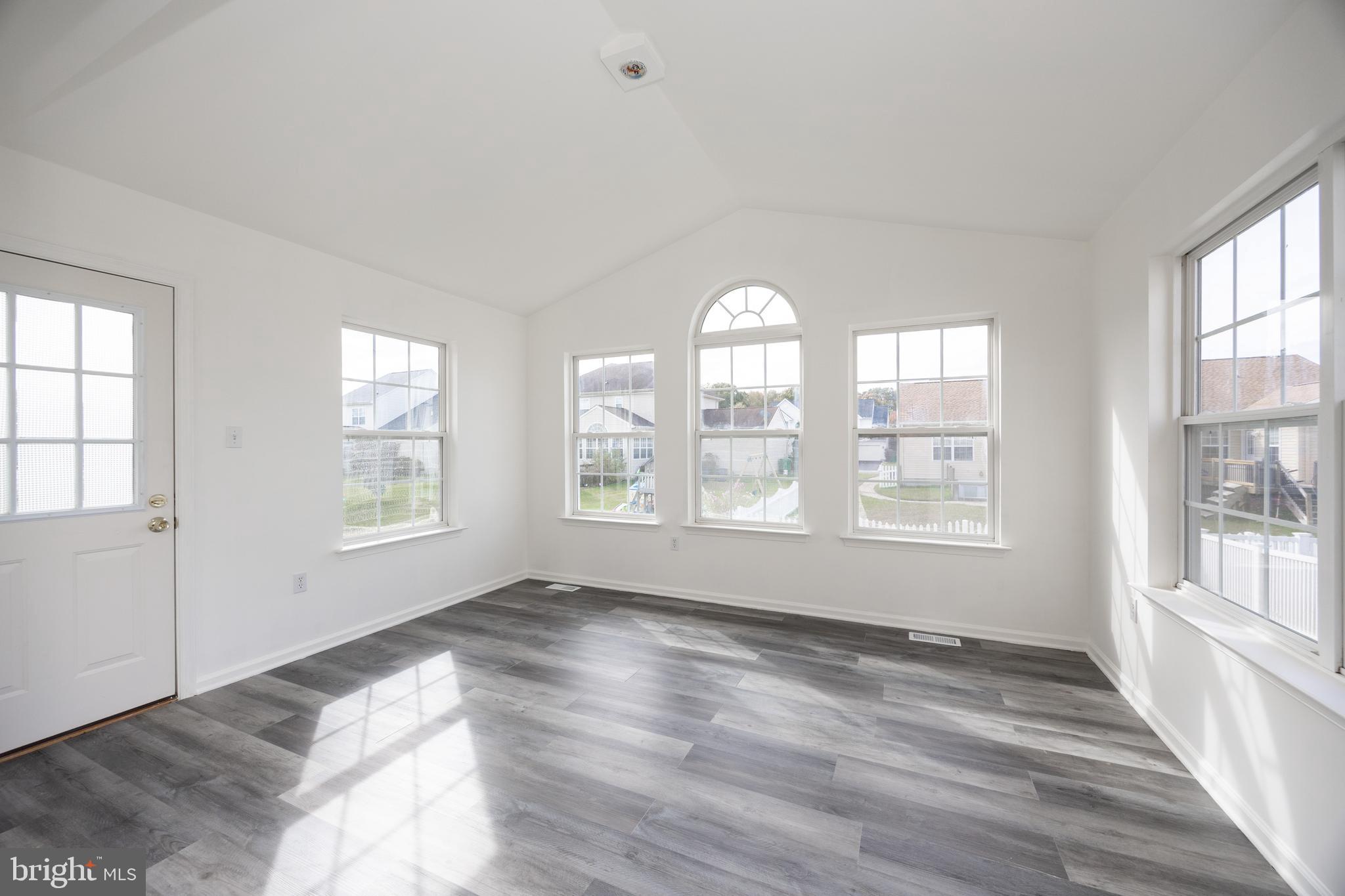 97 Needham Drive Smyrna, DE 19977 - Photo 11 of 52 a view of an empty room with a window and wooden floor