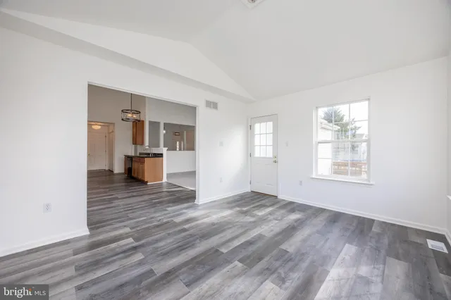 a kitchen with stainless steel appliances granite countertop wooden floors a stove and a window