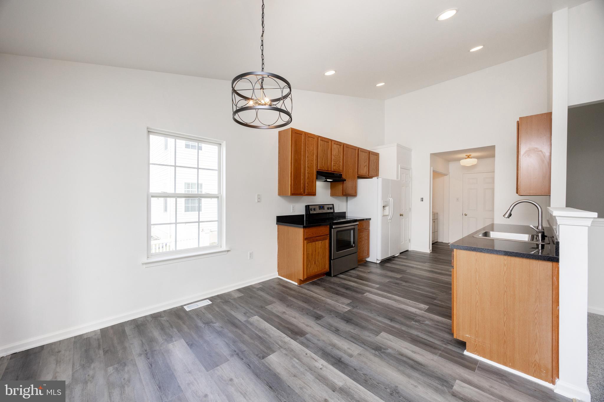 97 Needham Drive Smyrna, DE 19977 - Photo 14 of 52 a kitchen with stainless steel appliances granite countertop wooden floors a stove and a window