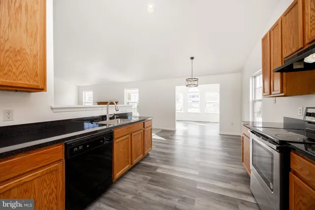 a view of empty room with wooden floor and windows