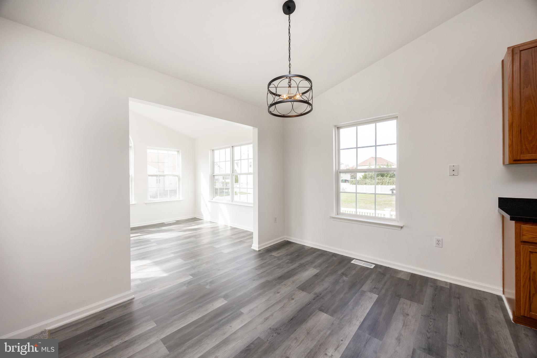 97 Needham Drive Smyrna, DE 19977 - Photo 17 of 52 a view of empty room with wooden floor and windows